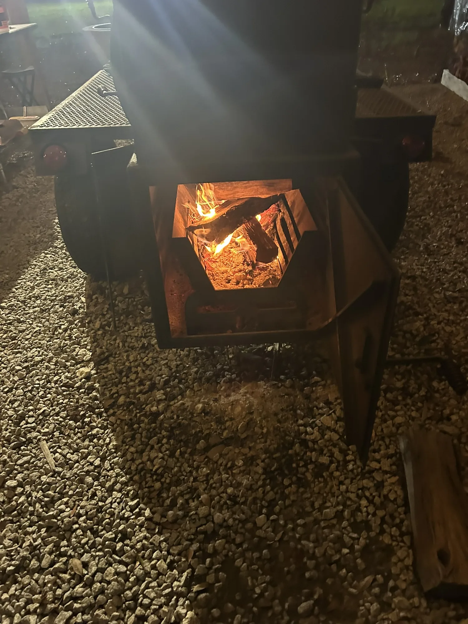 Smoker firebox glowing with flames at night